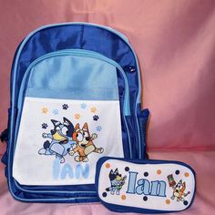 a blue backpack and bib set with cartoon characters on the front, along with a name tag