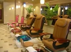 there are many chairs lined up in the room with hair dryers on each side