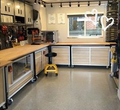 a large kitchen with lots of cabinets and tools on the counter top in front of a window