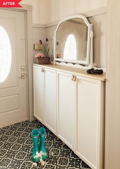 a pair of blue rubber boots sitting in front of a white cabinet with arched windows