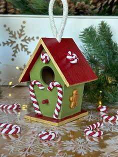 a green birdhouse with candy canes around it