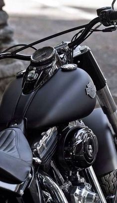 a black motorcycle parked next to a stone wall