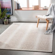 a living room area with a chair, window and rug on the floor in front of it