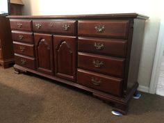 a large wooden dresser sitting on top of a carpeted floor