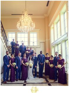 a group of people standing in front of a chandelier