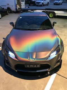 a car that is sitting in the parking lot with holographic paint on it