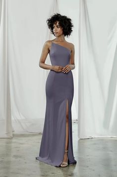 a woman in a purple dress posing for the camera