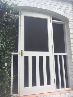 an open white door on the side of a brick building