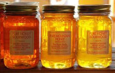 four jars of honey sit on a table