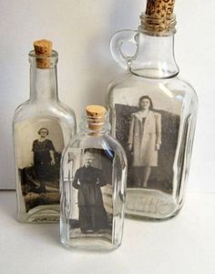 two empty glass bottles with pictures in them