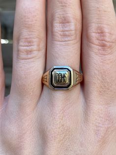 a close up of a person's hand wearing a ring with the word mom on it