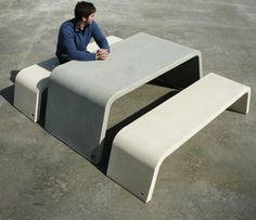 a woman sitting on a bench in an empty lot