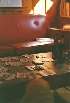 the table is covered with cards and beer bottles