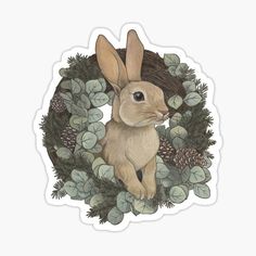 a brown rabbit sitting in the middle of a wreath with green leaves and pine cones