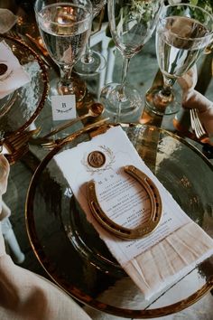 the table is set with wine glasses, napkins and place settings for an elegant dinner