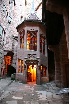 an old building is lit up by the light coming from it's windows and doors