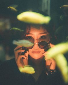 a woman holding up her glasses to the camera