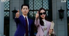 a man and woman in business attire giving thumbs up