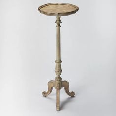 an old fashioned wooden table with a round top on it's legs and base