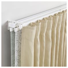 curtains hanging on the side of a wall with white trimmings and an open curtain rod