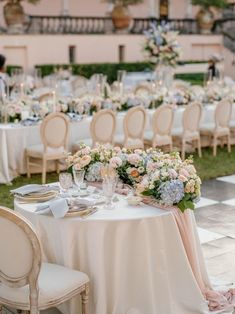 the tables are set with white linens and floral centerpieces for an elegant wedding reception