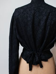 "Antique embroidered black blouse c. 1900 with gathering at the shoulders, long bishop sleeves with self fabric buttons at the cuffs and self fabric ties at the back. Metal snaps at the front. Feels like silk or a silk blend. - Size Small / Medium / Large - Blousy style tie to fit. Displayed unclipped on dress form with 35\" bust. Shoulder: 16\" Bust: 44\" - 46\" Waist: 42\" Length: 18.5\" Sleeve Length: 26\" Condition: Excellent! - One small hole as pictured. Only seen when held up to light. - Bishop Sleeve Shirt, Fabric Buttons, 80s Dress, Caftan Dress, Bishop Sleeve, Woven Dress, Dress Form, Embroidered Blouse, Sewing Inspiration