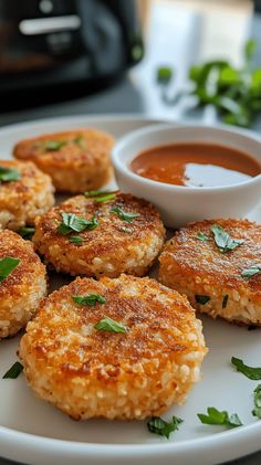 several crab cakes on a plate with dipping sauce