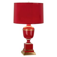 a red lamp with a gold base and a red lampshade on the bottom