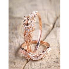 two wedding rings sitting on top of a piece of wood with diamonds in the middle