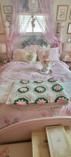 a bed with pink and green bedspread in a bedroom next to a window