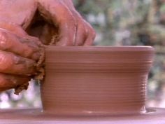 a person is making clay on a potter's wheel