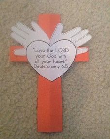 an orange cross with white wings and a bible verse on the side that says, love the lord your god with all your heart