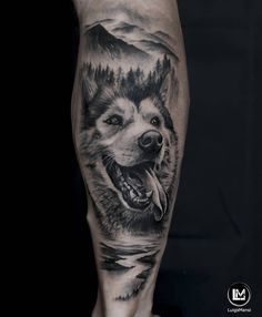 a man's leg with a black and white tattoo of a wolf on it