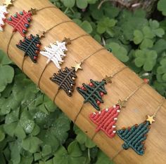 a bamboo stick with christmas decorations on it sitting in front of some green plants and leaves