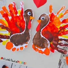 two turkeys made out of handprints on a piece of paper with hearts