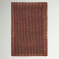 an orange and brown rug with vertical stripes on it, against a white wall background