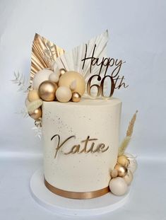 a birthday cake decorated with gold and white decorations