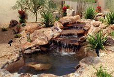 a small waterfall in the middle of a rock garden