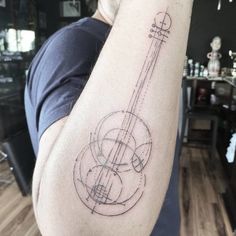 a man with a tattoo on his arm has a guitar in the shape of a circle