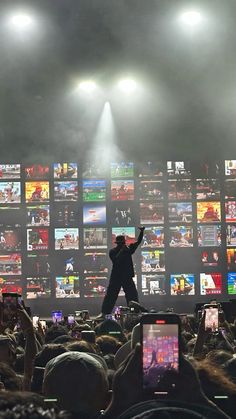 a man standing on top of a stage surrounded by lots of people