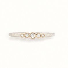 a three stone diamond ring on a white background