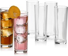 four glasses with different colored liquids and ice cubes in them, one has an orange slice on the rim