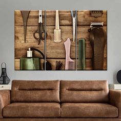 a brown couch sitting next to a wall covered in hair brushes and combs on top of a wooden floor