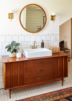 a bathroom with a sink, mirror and rug