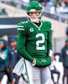 a football player wearing a green uniform on the field