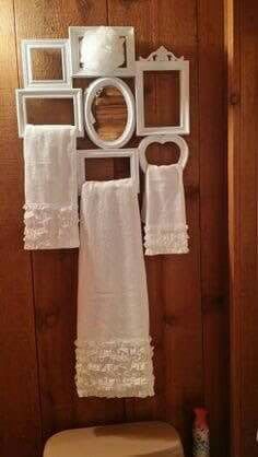 a white toilet sitting in a bathroom next to a wall mounted mirror and towel rack