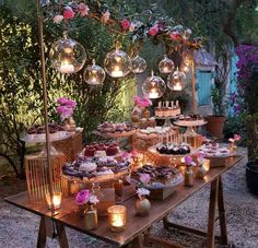 a wooden table topped with lots of cakes and desserts