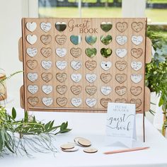 a wooden guest book with lots of hearts on it and place cards next to them