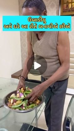 a man standing in front of a glass table holding a pan filled with food on top of it