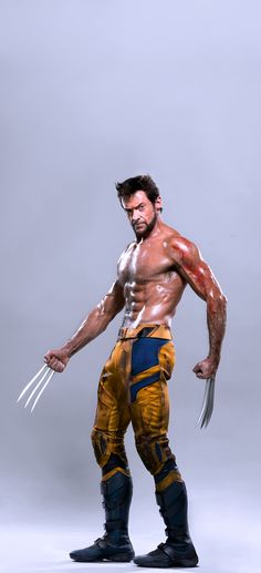 a man in yellow and blue wolverine costume posing for the camera with his claws out